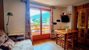 a living room with a table and a view of a balcony at Dorfgastein Mountain Property - Charming in Dorfgastein
