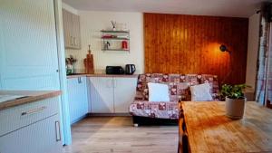 a kitchen and a living room with a couch and a table at Dorfgastein Mountain Property - Charming in Dorfgastein
