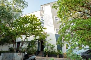 a white building with trees in front of it at Sivam Villa-Kovalam in Covelong