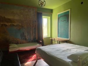 a bedroom with a bed and a painting on the wall at Rails and Vines in Tsinandali +11 photos