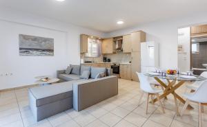 a living room and kitchen with a couch and a table at Arivaro Apartment in Souda