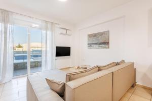 a living room with a couch and a tv at Arivaro Apartment in Souda