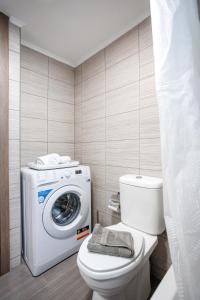 a bathroom with a washing machine and a toilet at Arivaro Apartment in Souda +44 photos