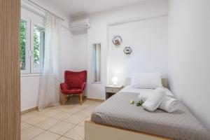 a bedroom with a bed and a red chair at Arivaro Apartment in Souda