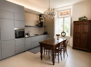 a kitchen with a table and chairs and a chandelier at Casa Vacanza Baragiola4 - Hotel San Giuseppe Group in Cernobbio