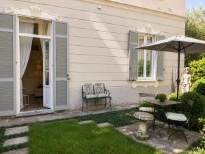 a patio with a table and chairs and an umbrella at Casa Vacanza Baragiola4 - Hotel San Giuseppe Group in Cernobbio