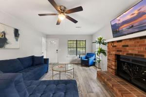 a living room with a blue couch and a fireplace at A Peaceful stay at The Pine Grove Retreat in Ladson