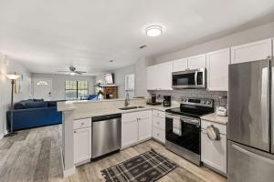 a kitchen with white cabinets and a blue couch at A Peaceful stay at The Pine Grove Retreat in Ladson