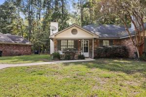 a brick house with a grass yard in front of it at A Peaceful stay at The Pine Grove Retreat in Ladson