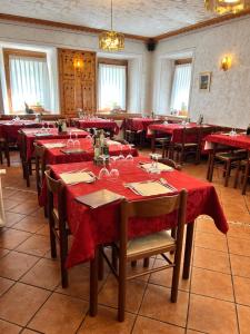 a dining room with red tables and chairs at Albergo Vecellio in Auronzo di Cadore