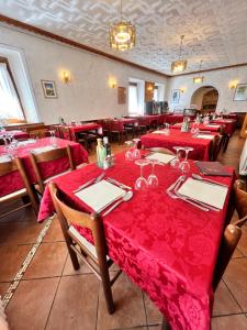 a restaurant with red tables and chairs with red table cloth at Albergo Vecellio in Auronzo di Cadore +16 photos