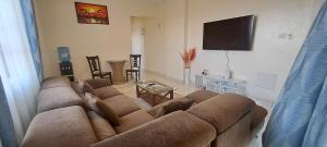 a living room with a couch and a flat screen tv at Seaview homestay on Third avenue beach apt- nyali in Mombasa