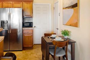 a kitchen with a table and a stainless steel refrigerator at Deep Blue Seaside in Monterey