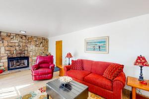a living room with a red couch and a fireplace at See Star Ranch in Nipomo