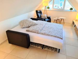 a bedroom with a bed and a chair in it at Ferienwohnung Grachtenhimmel in Greetsiel