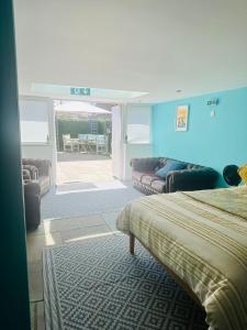 a room with two beds and a couch and a patio at Margate Summerhouse in Westgate-on-Sea