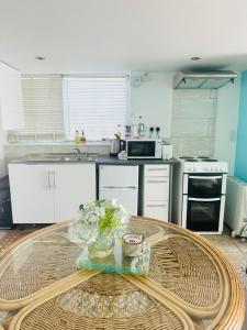 a kitchen with a table with flowers on it at Margate Summerhouse in Westgate-on-Sea
