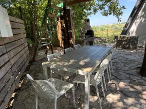 a wooden table and chairs on a patio at 1001 Noc Cazin - Oaza prirode i odmora in Mutnik