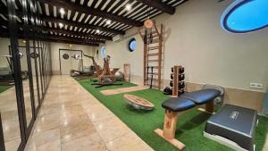 a room with a gym with a treadmill and a bench at Auberge de Cassagne & Spa in Le Pontet