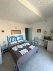 a bedroom with a large bed and a kitchen at Blue Street Apartments in Pythagoreio +11 photos