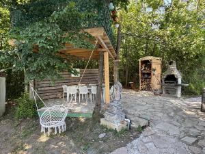 a patio with a table and chairs and a fireplace at 1001 Noc Cazin - Oaza prirode i odmora in Mutnik