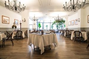 a dining room with tables and chairs and chandeliers at HOTEL LOS NAVEGANTES in Punta Arenas