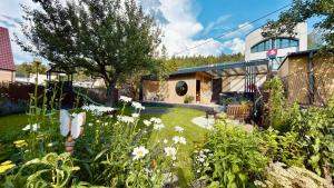 a garden with flowers in front of a house at Bonton Apartments in Kežmarok