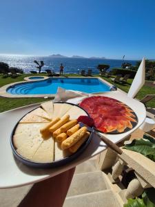 a plate of food on a table next to a pool at Gran Room do Mar in Oya