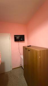 a room with a tv on a pink wall at Casa Valeria in Pescia