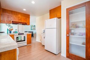 a kitchen with a white refrigerator and wooden cabinets at Morro Beach Bungalow in Morro Bay