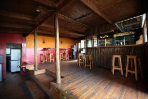 a restaurant with a bar with wooden floors and bar stools at Buccaneers Beach Lodge, Chintsa, South Africa in Chintsa