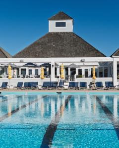 a swimming pool in front of a building at Tees & Tides in Nags Head