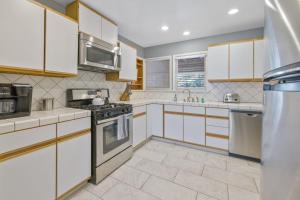 a kitchen with white cabinets and stainless steel appliances at Victory On Vine in Paso Robles +27 photos