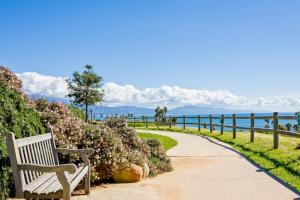 a bench sitting on a sidewalk next to a walkway at Sailaway Cabin A in Ventura