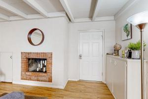 a living room with a brick fireplace and a mirror at Sailaway Cabin A in Ventura