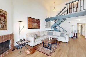 ein Wohnzimmer mit einem weißen Sofa und einer Treppe in der Unterkunft Gateshead Haven in Oxnard