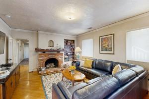 a living room with a leather couch and a fireplace at Urban Ventura Oasis in Ventura