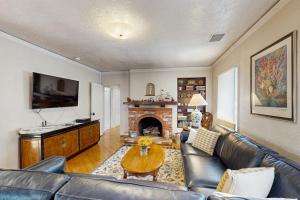 a living room with a leather couch and a fireplace at Urban Ventura Oasis in Ventura