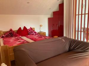 a bedroom with a large bed with red pillows at Sissy Appartment in Kössen