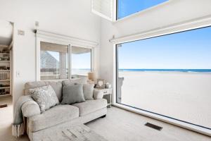 a living room with a couch and a large window at Sandcastle by the Sea in Oxnard +28 photos