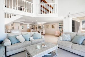 a living room with two couches and a table at Sandcastle by the Sea in Oxnard