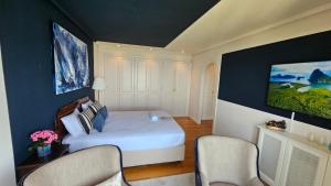 a bedroom with a white bed and two chairs at Ocean View Room Oia in Oya