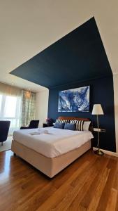 a bedroom with a large bed with a blue wall at Ocean View Room Oia in Oya +35 photos