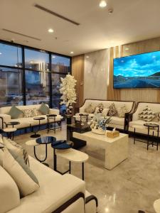 a living room with couches and tables and a large screen at فندق لوشال LECHAL Hotel in Medina