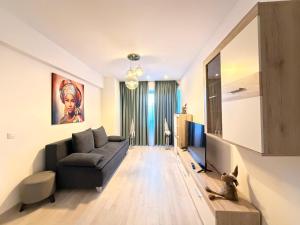 a living room with a couch and a tv at Ariana Deluxe Suites in Bucharest
