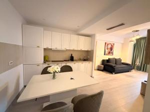 a kitchen and living room with a table and chairs at Ariana Deluxe Suites in Bucharest