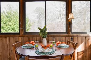 a dining room table with a vase of flowers on it at Spacious Mins from Beach & Dogs Welcome in Eastham