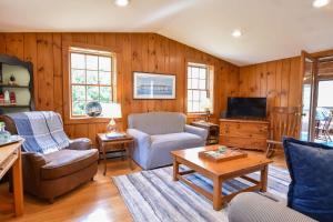 a living room with wood paneling and a tv at Spacious Mins from Beach & Dogs Welcome in Eastham +24 photos