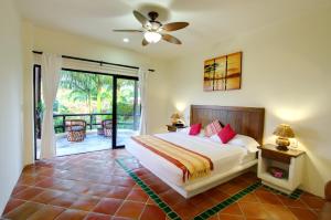 a bedroom with a bed and a sliding glass door at Las Palmas Oceanfront Villas and Casitas in Santa Cruz Huatulco +107 photos