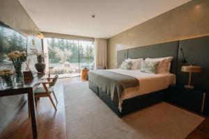 a bedroom with a large bed and a desk and a window at Quinta de Silvalde in Santo Tirso +159 photos